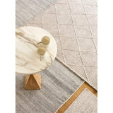 da Grey recycled plastic bottle rug by Claire Gaudion. Lifestyle image of layered rugs and marble side table.
