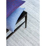 Ida Grey recycled plastic bottle rug by Claire Gaudion. Rug with chair and cushions. 
