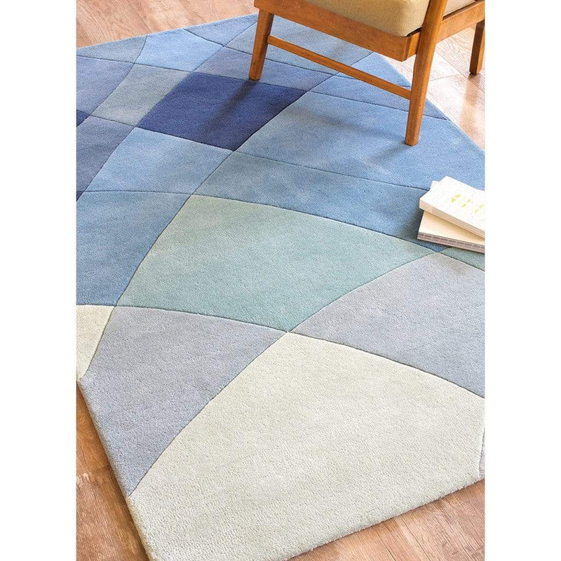 Rhythmic Tides Rug is a modern ocean themed rug that celebrates the sea. This coast rug is blue-green in colour and has an organic curved pattern which depicts the ebb and flow of the tides. Close up lifestyle image.